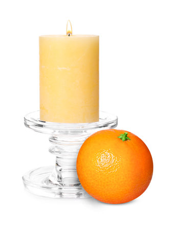 Citrus scented candle and fresh tangerine isolated on whiteの写真素材