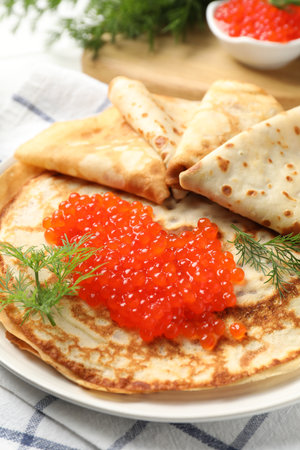 Delicious crepes with red caviar and dill on table, closeupの写真素材