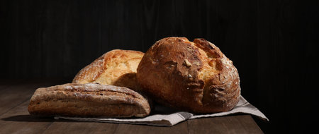 Different types of bread loaves on wooden table, closeupの写真素材