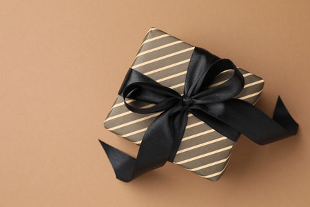 Beautiful wrapped gift on brown background, top view. Space for textの写真素材