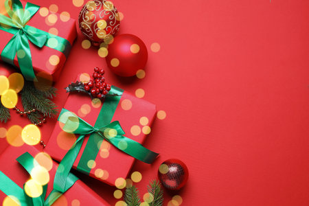 Wrapped Christmas gifts and decor on red background, flat lay. Space for textの写真素材