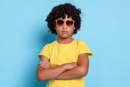 Portrait of little boy with sunglasses on light blue background