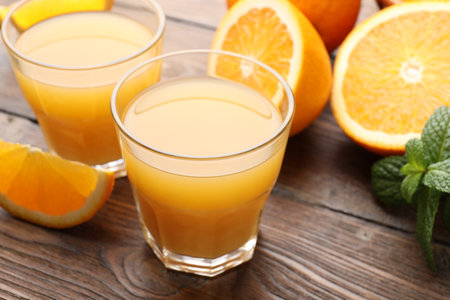Fresh orange juice, mint and fruits on wooden table, closeupの写真素材