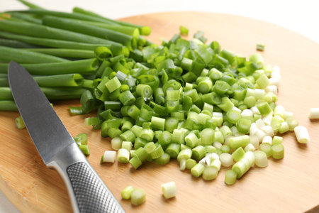 Cut fresh green onions and knife on table, closeupの写真素材