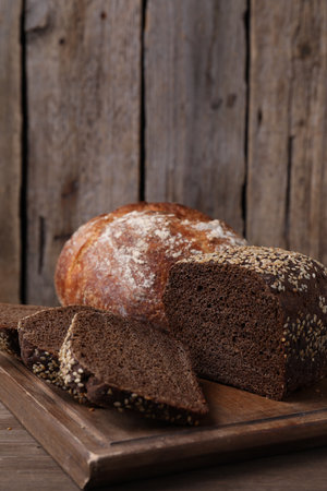 Different types of bread on wooden table, closeup