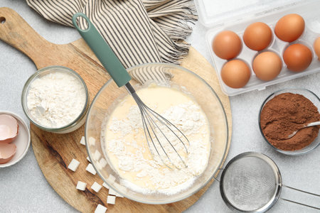 Different ingredients for dough on gray table, flat lay
