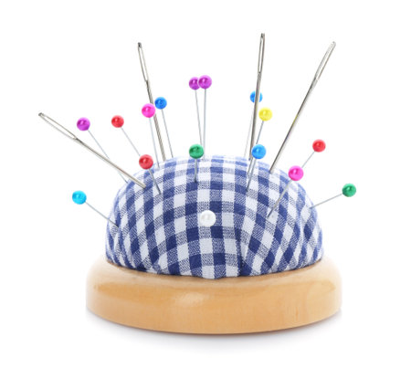 Checkered pincushion with pins and needles isolated on white. Sewing accessoryの写真素材