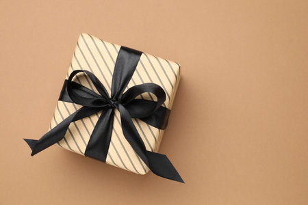 Beautiful wrapped gift on brown background, top view. Space for textの写真素材