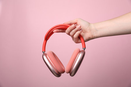Woman with stylish headphones on pink background, closeupの写真素材
