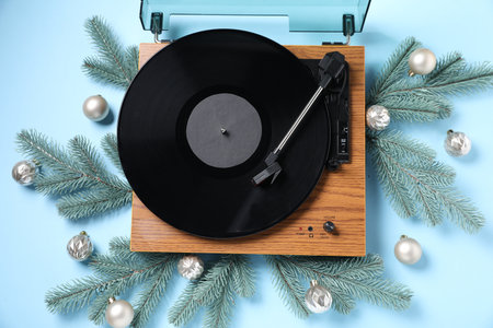 Wooden turntable with vinyl record and Christmas decor on light blue background, flat layの写真素材