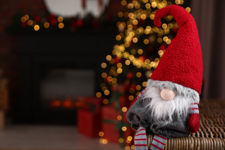 Funny Christmas gnome in decorated room, closeup. Space for textの写真素材