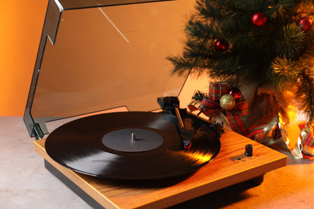 Turntable with vinyl record and Christmas decor on light tableの写真素材