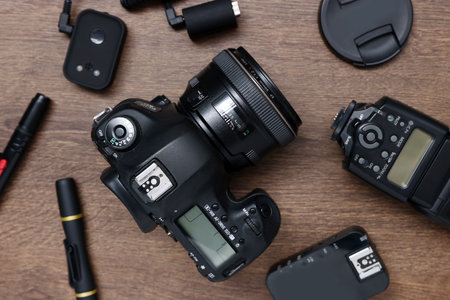 Professional photographer's equipment on wooden table, flat lay
