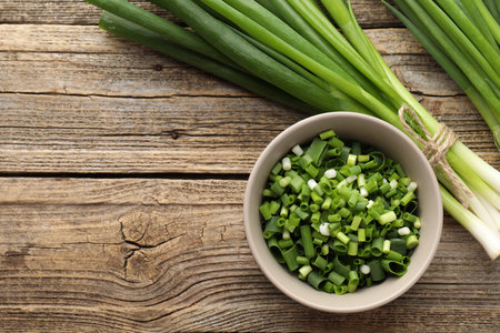 Fresh green onions on wooden table, flat lay. Space for textの写真素材
