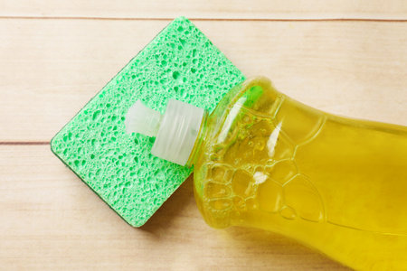 Clean kitchen sponge and dish soap on wooden table, top viewの写真素材