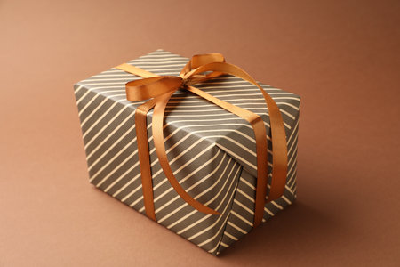 Beautiful wrapped gift on brown background, closeupの写真素材