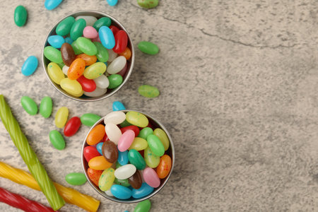 Delicious colorful candies on gray table, flat lay. Space for textの写真素材