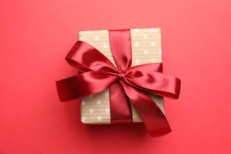Beautiful gift with bow on red background, top viewの写真素材