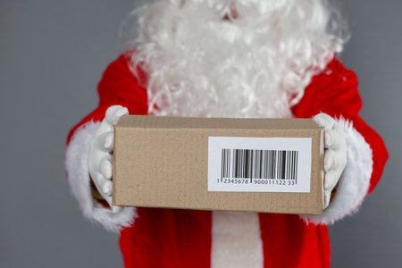 Santa Claus with parcel on gray background, closeupの写真素材