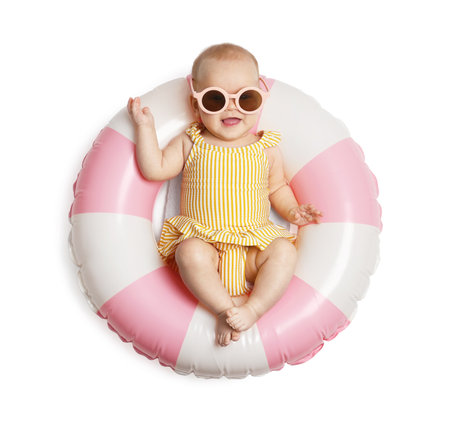 Cute little baby with sunglasses on inflatable ring against white background, top viewの写真素材