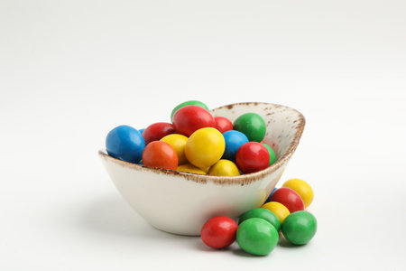 Delicious colorful candies in bowl isolated on white