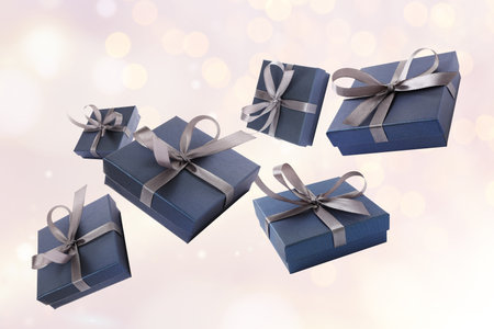 Gift boxes flying in air on light background with bokeh lights
