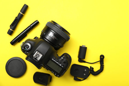 Professional photographer's equipment on yellow background, flat lay. Space for textの写真素材