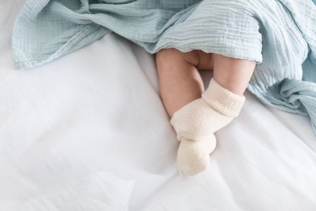 Cute newborn baby wrapped with blanket on bed, above view. Space for text