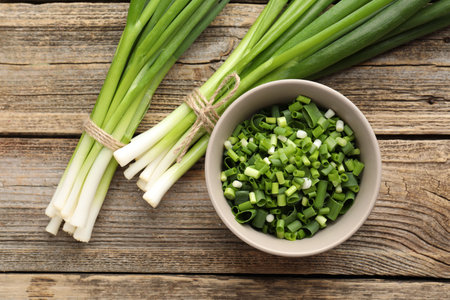 Fresh green onions on wooden table, flat layの写真素材