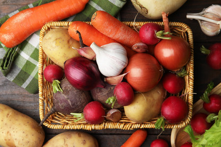Different raw vegetables on wooden table, flat lay