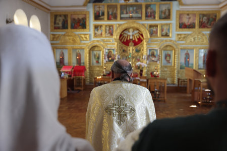 Mykolaiv, Ukraine - November 1, 2025: Priest conducting baptism ceremony in church, back view