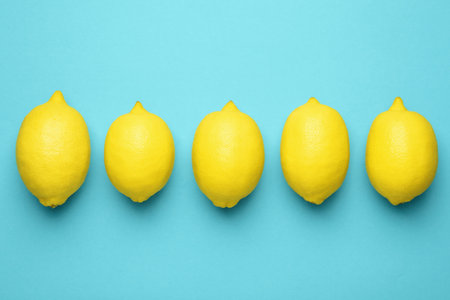 Fresh ripe lemons on light blue background, flat layの写真素材