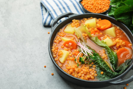 Tasty lentil soup in bowl on gray table, closeup. Space for textの写真素材
