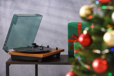 Turntable with vinyl record, gift boxes and Christmas tree in room, selective focusの写真素材