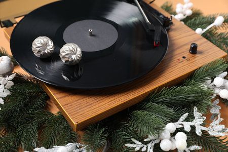 Wooden turntable with vinyl record and Christmas decor on beige background, closeupの写真素材