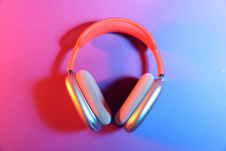 Stylish headphones on color background, top view