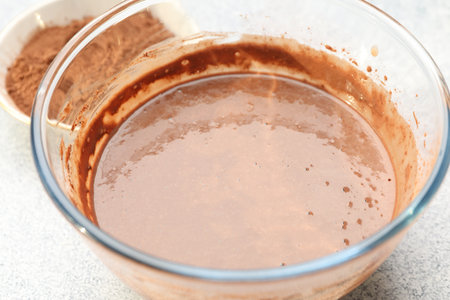Chocolate dough in glass bowl on gray textured table, closeupの写真素材