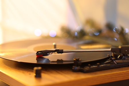 Turntable with vinyl record and Christmas decor on table, closeup