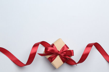 Beautiful red ribbon on light background, top view. Space for textの写真素材