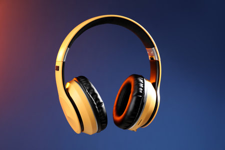 Pair of stylish headphones in air on color gradient background