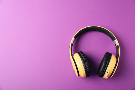 Stylish headphones on violet background, top view. Space for textの写真素材