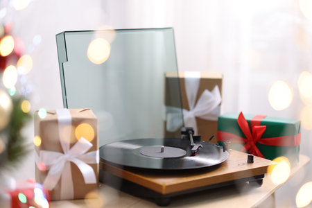 Turntable with vinyl record and gift boxes on wooden table. Christmas musicの写真素材