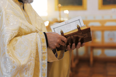 Priest with Holy Bible in church, closeup