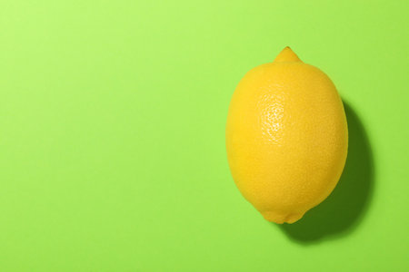 Fresh ripe lemon on light green background, top view. Space for textの写真素材