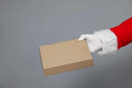 Santa Claus with parcel on gray background, closeupの写真素材