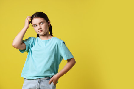 Portrait of cute girl on yellow background, space for text