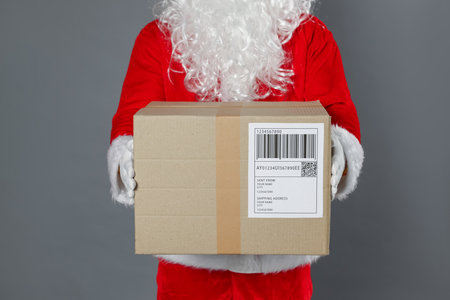 Santa Claus with parcel on gray background, closeup