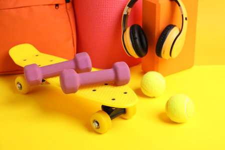 Headphones and sports equipment on yellow background, closeupの写真素材