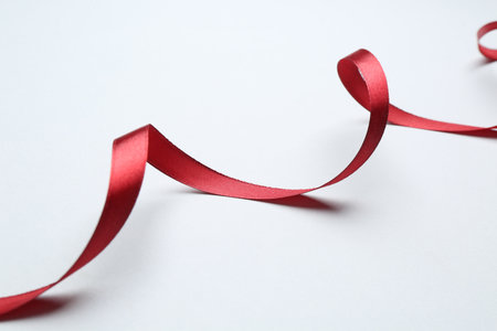 Beautiful red ribbon on light background, closeupの写真素材