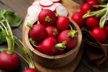 Fresh radishes in bowl on wooden table, closeupの写真素材